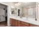 Bathroom featuring a double sink vanity, large mirrors, and a walk-in closet for extra storage at 2042 W Mark Ln, Phoenix, AZ 85085