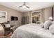 Nicely furnished bedroom featuring a ceiling fan, dresser, and sliding glass doors to the outdoor patio at 2042 W Mark Ln, Phoenix, AZ 85085