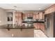 Well-lit kitchen featuring granite countertops, stainless steel appliances, and wooden cabinetry at 2042 W Mark Ln, Phoenix, AZ 85085