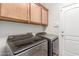 Laundry room with overhead cabinets and modern washer and dryer units at 2042 W Mark Ln, Phoenix, AZ 85085