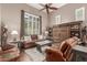 Cozy living room with leather furniture, hardwood floors, and a stylish wooden storage cabinet at 2042 W Mark Ln, Phoenix, AZ 85085
