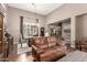 Spacious living room featuring hardwood floors, a leather sofa, and an open layout at 2042 W Mark Ln, Phoenix, AZ 85085