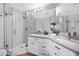 Bathroom with double sinks, modern fixtures, and a glass-enclosed shower featuring decorative tiling at 20822 N 34Th Dr, Phoenix, AZ 85027