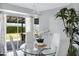 Dining area features glass table with white chairs, modern lighting, and view to the backyard at 20822 N 34Th Dr, Phoenix, AZ 85027