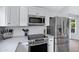 Modern kitchen features stainless steel appliances, white cabinetry, mosaic backsplash, and granite countertops at 20822 N 34Th Dr, Phoenix, AZ 85027