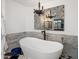 Chic bathroom with black and white checkered tile, marble wall tile, and a standalone bathtub with an accent chandelier at 2211 E Camelback Rd # 902, Phoenix, AZ 85016