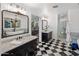 Elegant bathroom featuring checkered floors, dual vanities, a freestanding tub, and a glass-enclosed shower at 2211 E Camelback Rd # 902, Phoenix, AZ 85016