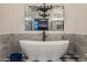 Stylish bathroom featuring marble wall tile, black and white checkered floors, and a modern standalone bathtub at 2211 E Camelback Rd # 902, Phoenix, AZ 85016