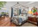 Inviting bedroom with hardwood floors, canopy bed, and comfortable sitting area with city views at 2211 E Camelback Rd # 902, Phoenix, AZ 85016