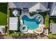 Aerial shot of the backyard showcasing a uniquely shaped pool, spa, rock waterfall, and covered patio at 22771 N 98Th Dr, Peoria, AZ 85383