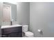 Cozy half bathroom with sleek fixtures, vanity, and toilet at 22771 N 98Th Dr, Peoria, AZ 85383