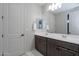 Bathroom featuring double sinks, dark wood cabinets, and a large vanity mirror at 22771 N 98Th Dr, Peoria, AZ 85383