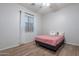 Neutral bedroom with wood-look floors, window and bed with pink comforter at 22771 N 98Th Dr, Peoria, AZ 85383