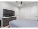 Well-lit bedroom with a mounted TV, neutral decor, and ample closet space at 22771 N 98Th Dr, Peoria, AZ 85383