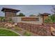 A stone welcome sign at the community entrance greets residents with its rustic design and landscaping at 22771 N 98Th Dr, Peoria, AZ 85383
