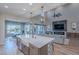 Open kitchen featuring a large island with a farm sink, stainless appliances, and modern pendant lights at 22771 N 98Th Dr, Peoria, AZ 85383