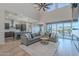 Spacious living room with large windows, natural light, and view of gourmet kitchen and outdoor patio at 22771 N 98Th Dr, Peoria, AZ 85383