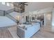 Bright living room featuring an open floor plan, a staircase, and modern kitchen with stainless steel appliances at 22771 N 98Th Dr, Peoria, AZ 85383