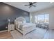Serene main bedroom features an accent wall, neutral decor, and a sitting area with views of the backyard at 22771 N 98Th Dr, Peoria, AZ 85383