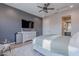 The main bedroom showcases a dark accent wall, neutral decor, a television, and access to a private bath at 22771 N 98Th Dr, Peoria, AZ 85383
