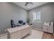 Bright home office features a large desk, modern ceiling fan, and neutral decor at 22771 N 98Th Dr, Peoria, AZ 85383