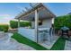 An outdoor kitchen area with bar seating and lighting next to a pool and yard at 22771 N 98Th Dr, Peoria, AZ 85383