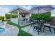Outdoor kitchen and dining area with a built-in grill, bar seating, and a pergola for shade at 22771 N 98Th Dr, Peoria, AZ 85383