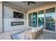 Covered patio featuring an electric fireplace, mounted TV, and comfortable seating, seamlessly blending indoor and outdoor living at 22771 N 98Th Dr, Peoria, AZ 85383