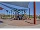 Fun playground area, with slides and climbing structures under a shade canopy, surrounded by landscaped grounds at 22771 N 98Th Dr, Peoria, AZ 85383