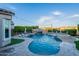 Resort-style backyard with a large pool, waterfall, slide, spa, and lush landscaping at 22771 N 98Th Dr, Peoria, AZ 85383
