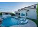 Backyard featuring a pool with lounge chairs, spa, outdoor kitchen, and beautiful landscaping at 22771 N 98Th Dr, Peoria, AZ 85383