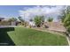 Serene backyard with artificial turf, mature trees, and a privacy wall at 22960 N 94Th Ln, Peoria, AZ 85383