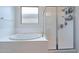 Bright bathroom with a garden tub and a frameless glass shower stall at 22960 N 94Th Ln, Peoria, AZ 85383