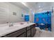 Bathroom featuring double sinks, a large mirror and a blue themed shower curtain at 22960 N 94Th Ln, Peoria, AZ 85383