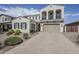Two-story stucco home featuring a paved driveway, attached two-car garage, and manicured landscaping at 22960 N 94Th Ln, Peoria, AZ 85383