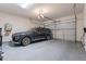Spacious garage with a modern vehicle, epoxy flooring, and ample storage space at 22960 N 94Th Ln, Peoria, AZ 85383