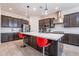 Spacious kitchen showcasing a large island, stainless steel appliances, and sleek pendant lighting at 22960 N 94Th Ln, Peoria, AZ 85383