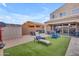 Spacious backyard with a hot tub, lounge chairs, artificial turf, and shaded patio area at 2322 E Mews Rd, Gilbert, AZ 85298