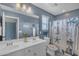 Bright bathroom with double sink vanity, decorative shower curtain, and an oversized mirror at 2322 E Mews Rd, Gilbert, AZ 85298