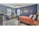 This bright bedroom offers a bed, desk, and large window for natural light and backyard views at 2322 E Mews Rd, Gilbert, AZ 85298