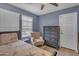 Charming bedroom featuring a chair, ceiling fan, plantation shutters, and dark wood furniture at 2322 E Mews Rd, Gilbert, AZ 85298