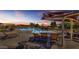 Inviting community pool area with lounge chairs, tables, umbrellas, and adjacent playground at 2322 E Mews Rd, Gilbert, AZ 85298