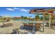 Inviting community pool area with lounge chairs, tables, umbrellas, and adjacent playground at 2322 E Mews Rd, Gilbert, AZ 85298