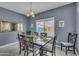 Cozy dining room features a dark wood table with seating for six and a bright window overlooking the backyard at 2322 E Mews Rd, Gilbert, AZ 85298
