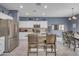 This bright kitchen includes an island with seating, stainless steel appliances, and a view into the dining area at 2322 E Mews Rd, Gilbert, AZ 85298