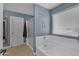 Bright main bathroom featuring a separate shower, soaking tub, and large window at 2322 E Mews Rd, Gilbert, AZ 85298