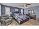This spacious main bedroom features a ceiling fan, a sitting area and a large bed with floral bedding at 2322 E Mews Rd, Gilbert, AZ 85298