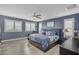 Serene main bedroom with a ceiling fan, blue walls, and stylish bedding, creating a relaxing retreat at 2322 E Mews Rd, Gilbert, AZ 85298