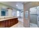 Well-lit bathroom featuring double vanity, granite countertops, bathtub, and tiled shower with glass door at 23773 W Hammond Ln, Buckeye, AZ 85326