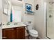 Bathroom featuring a vanity with dark wood cabinets, toilet, and a glass door shower at 25606 W Satellite Ln, Buckeye, AZ 85326